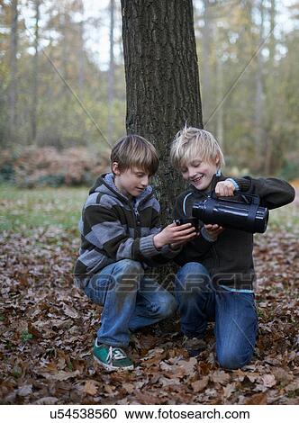 Boys pouring hot drink from flask in forest View Large Photo Image Stock Image - Boys pouring hot drink from flask in forest. Fotosearch