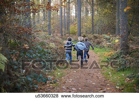 Stock Photo - Boys running through forest. Fotosearch