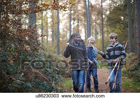 Boys walking through forest with fishing equipment View Large Photo Image Stock Image - Boys walking through forest with fishing equipment. Fotosearch