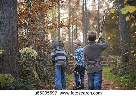 Boys walking through forest with fishing equipment View Large Photo Image Stock Photo - Boys walking through forest with fishing equipment. Fotosearch