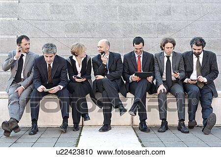 Business people sitting in a row and working outdoors View Large Photo Image Stock Image - Business people sitting in a row and working outdoors. Fotosearch