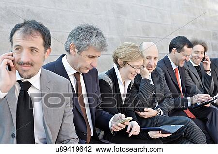 Business people sitting in a row and working outdoors View Large Photo Image Stock Image - Business people sitting in a row and working outdoors. Fotosearch