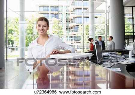 Business woman leaning against reception desk View Large Photo Image Stock Photograph - Business woman leaning against reception desk. Fotosearch