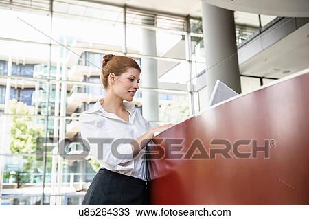 Business woman using laptop on reception desk View Large Photo Image Stock Image - Business woman using laptop on reception desk. Fotosearch