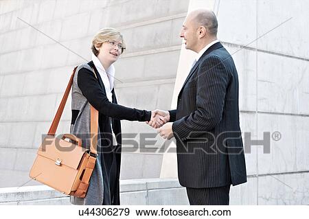 Stock Photo - Businesswoman and man shaking hands. Fotosearch
