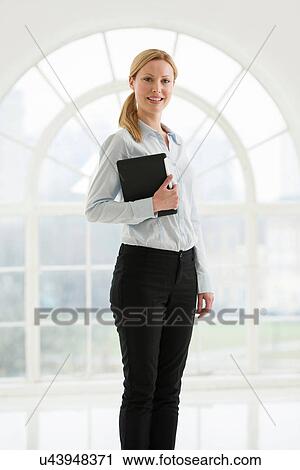 Stock Image - Businesswoman holding digital tablet. Fotosearch