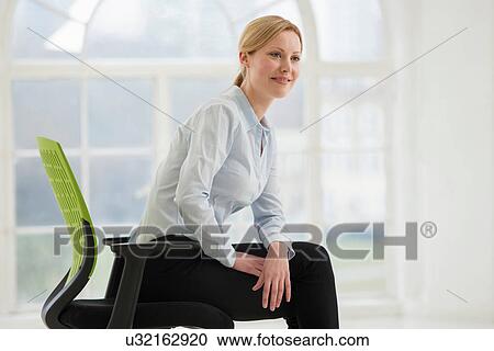 Businesswoman sitting on office chair View Large Photo Image Stock Image - Businesswoman sitting on office chair. Fotosearch