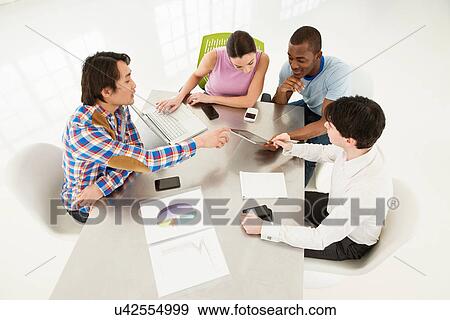 Stock Photo - Casual business meeting, high angle. Fotosearch