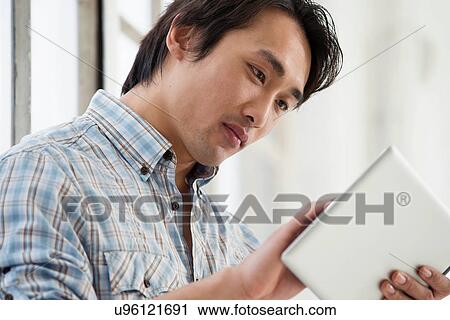 Casual businessman using digital tablet View Large Photo Image Stock Image - Casual businessman using digital tablet. Fotosearch