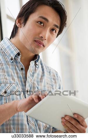 Casual businessman using digital tablet View Large Photo Image Stock Photo - Casual businessman using digital tablet. Fotosearch