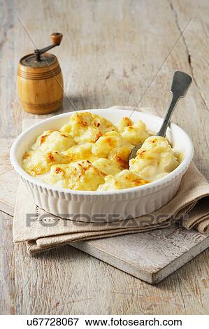Cauliflower cheese in large bowl with spoon and wooden pepper grinder View Large Photo Image Stock Photo - Cauliflower cheese in large bowl with spoon and wooden pepper grinder. Fotosearch