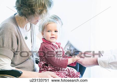 Child on mother's lap being examined by doctor View Large Photo Image Stock Image - Child on mother's lap being examined by doctor. Fotosearch
