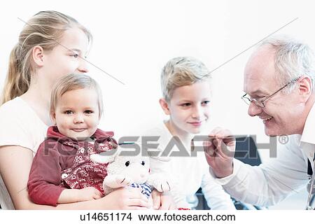 Child on sister's lap being examined by doctor View Large Photo Image Picture - Child on sister's lap being examined by doctor. Fotosearch