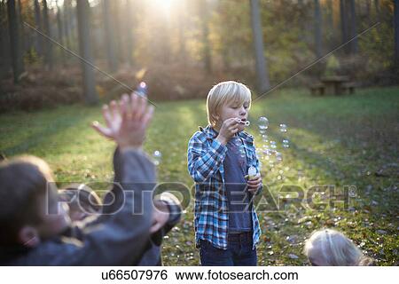 Children playing with bubbles in forest View Large Photo Image Stock Photograph - Children playing with bubbles in forest. Fotosearch