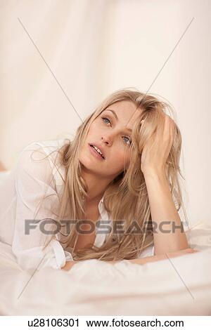 Close up portrait of a young blond woman lying on bed View Large Photo Image Stock Image - Close up portrait of a young blond woman lying on bed. Fotosearch
