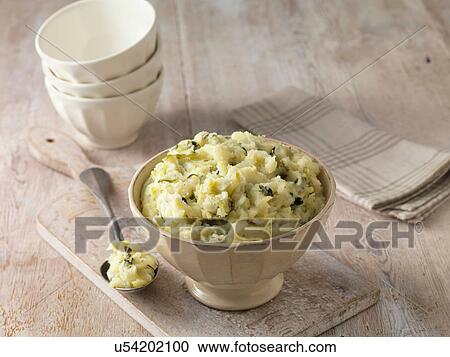 Stock Image - Colcannon potato mash in cream faceted bowl with metal spoon. Fotosearch