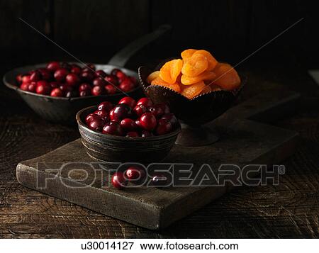 Cranberries and dried apricots on dark wooden board View Large Photo Image Stock Photo - Cranberries and dried apricots on dark wooden board. Fotosearch