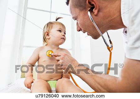 Doctor examining toddler girl with stethoscope View Large Photo Image Stock Image - Doctor examining toddler girl with stethoscope. Fotosearch