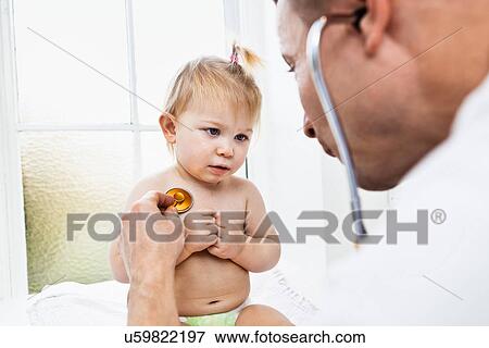 Stock Photo - Doctor examining toddler girl with stethoscope. Fotosearch