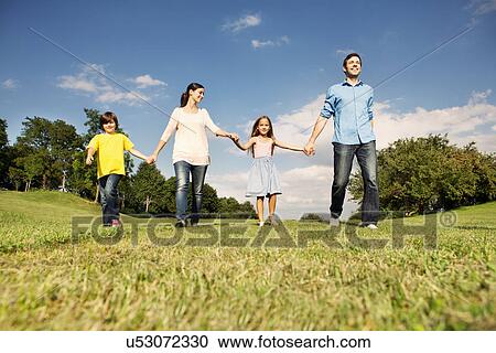 Family with two children holding hands, walking View Large Photo Image Stock Image - Family with two children holding hands, walking. Fotosearch