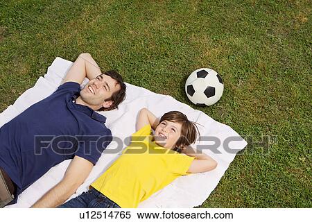 Father and son lying on blanket with football, high angle View Large Photo Image Stock Photography - Father and son lying on blanket with football, high angle. Fotosearch