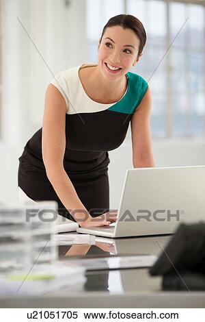 Stock Photography - Female office worker using laptop. Fotosearch