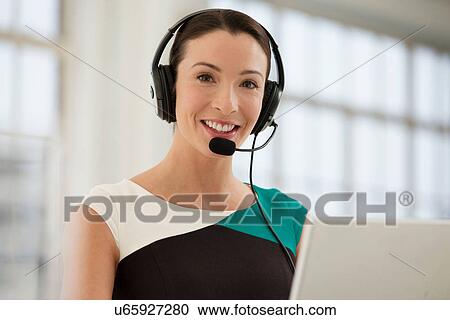 Stock Image - Female telephonist wearing headset. Fotosearch