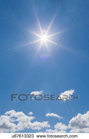 Stock Image - Fluffy clouds blue sky and sunlight. Fotosearch
