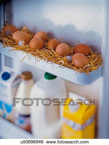 Stock Photograph - Freshly laid eggs in straw in refrigerator. Fotosearch