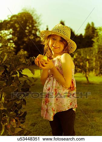 Girl holding an apple View Large Photo Image Stock Image - Girl holding an apple. Fotosearch