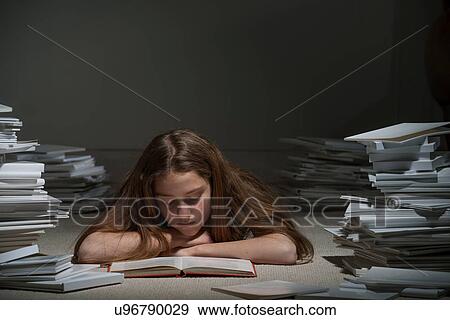 Girl lying on front reading book View Large Photo Image Stock Photo - Girl lying on front reading book. Fotosearch