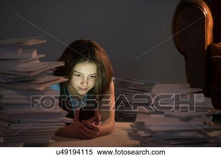 Girl lying on front using cell smartphone surrounded by books View Large Photo Image Stock Photography - Girl lying on front using cell smartphone surrounded by books. Fotosearch