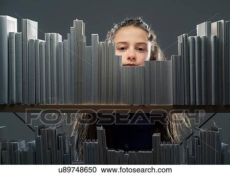Girl peeking between books on bookshelf View Large Photo Image Stock Image - Girl peeking between books on bookshelf. Fotosearch