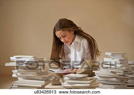 Girl sitting on floor reading surrounded by piles of books View Large Photo Image Stock Image - Girl sitting on floor reading surrounded by piles of books. Fotosearch