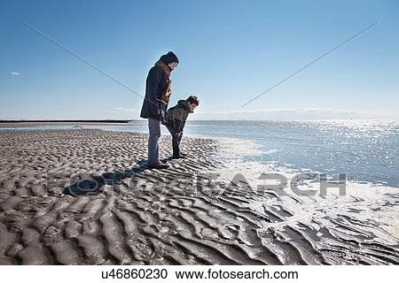 Stock Image - Grandmother and grandson on beach. Fotosearch