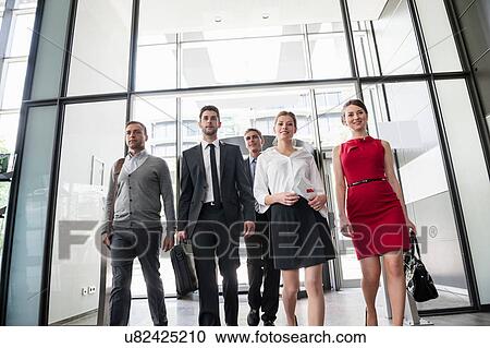 Group of business people entering glass office building View Large Photo Image Stock Image - Group of business people entering glass office building. Fotosearch