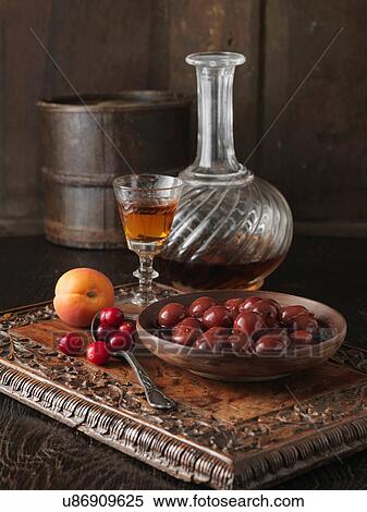 Stock Photography - Ingredients for cranberry and Morello cherry stuffing. Cranberries, Morello cherries, apricots and brandy on carved wooden board. Fotosearch