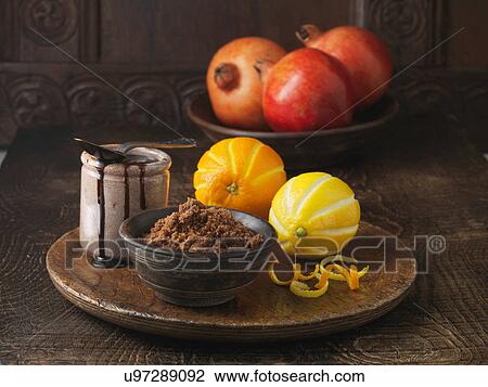 Stock Image - Ingredients for dry cured pork loin. Brown sugar, molasses, pomegranates and orange and lemon rind. Fotosearch