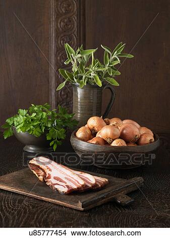 Picture - Ingredients to make stuffing. Pancetta, brown onions, parsley and sage on rustic wooden surface. Fotosearch