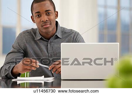 Male office worker sitting at desk View Large Photo Image Stock Image - Male office worker sitting at desk. Fotosearch