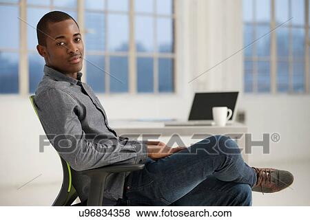 Stock Photo - Male office worker sitting at desk. Fotosearch