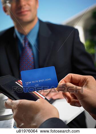 Picture - Man with wallet making credit card payment. Fotosearch