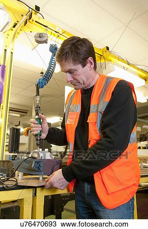 Man working on machinery in electrical component factory View Large Photo Image Stock Image - Man working on machinery in electrical component factory. Fotosearch