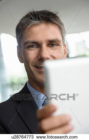 Mature businessman using digital tablet View Large Photo Image Stock Image - Mature businessman using digital tablet. Fotosearch