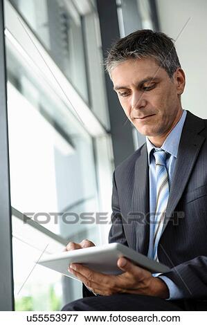Stock Photo - Mature businessman using digital tablet. Fotosearch