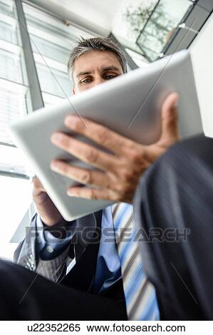 Stock Photography - Mature businessman using digital tablet. Fotosearch