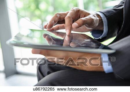 Mature businessman using digital tablet View Large Photo Image Stock Photography - Mature businessman using digital tablet. Fotosearch