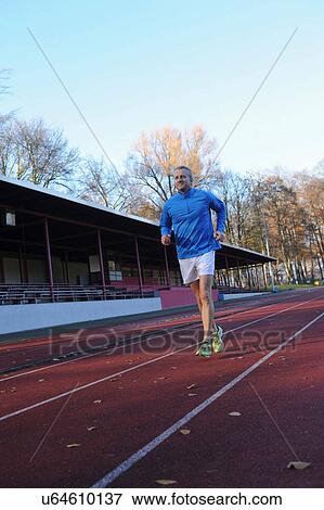 Mature man running on sports track View Large Photo Image Stock Photo - Mature man running on sports track. Fotosearch