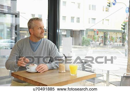Mature man sitting in coffee shop View Large Photo Image Stock Photography - Mature man sitting in coffee shop. Fotosearch