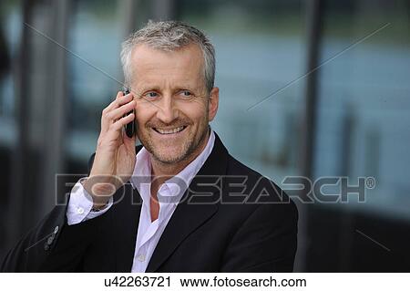 Mature man using cellphone and smiling View Large Photo Image Stock Image - Mature man using cellphone and smiling. Fotosearch